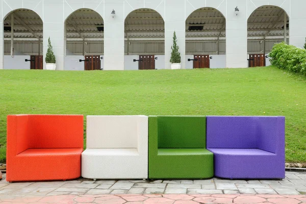 Colorato divano in rattan artificiale accanto al cortile verde — Foto Stock