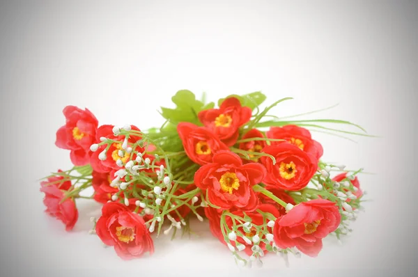 Искусственные красные цветы на фоне виньетки . — стоковое фото