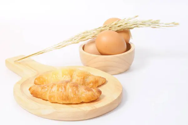 Двойные круассаны и свежие яйца с деревянной посудой — стоковое фото