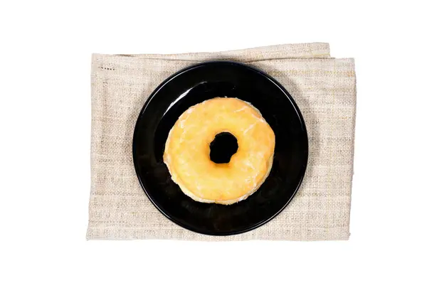 Donut in black plate on napkin — Stock Photo, Image