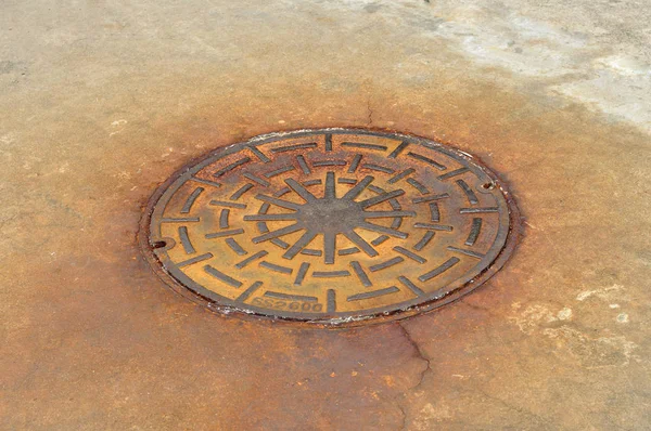 Rusty manhole cover on street, drain cover top view. — Stock Photo, Image