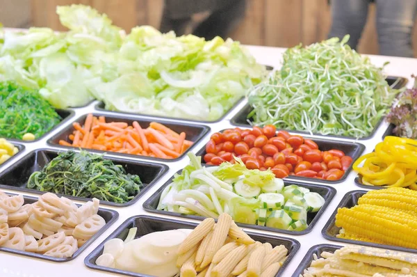 Olika grönsaker blandas på salladsbar. — Stockfoto