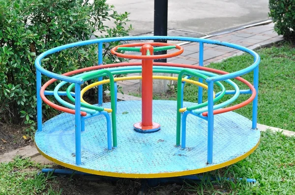 Renkli atlıkarınca üstünde yeşil Bahçe, çocuk oyun alanı — Stok fotoğraf