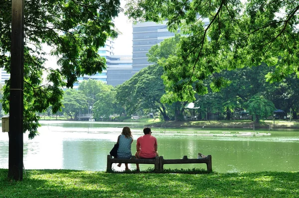 夫妻爱在岩石大湖旁的长凳上坐在一起 — 图库照片
