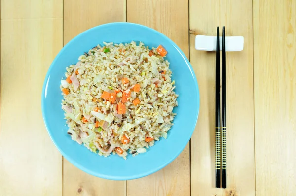 Presunto de frango arroz frito com cenoura em prato azul montado na mesa — Fotografia de Stock