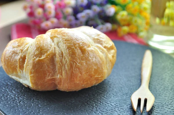 Croissant-Brot mit Holzgabel und Blume — Stockfoto