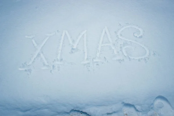 Navidad escrita a mano sobre nieve fresca . — Foto de Stock