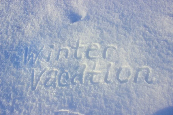 Vacaciones de invierno escritas a mano sobre nieve fresca . — Foto de Stock