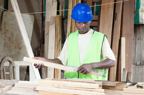 Плотник берет меру доски
.