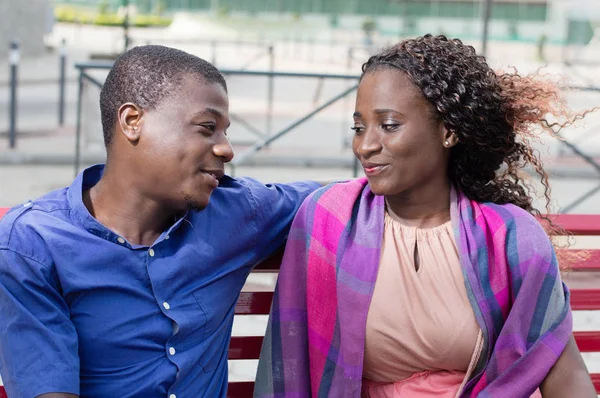 Young couple sitting on a bench — Stock Photo, Image