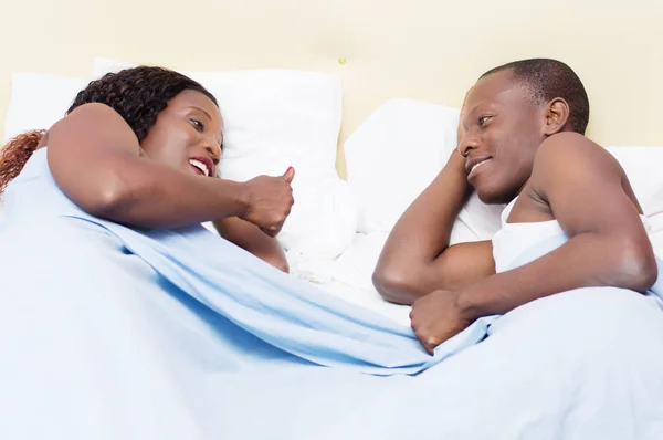 Young couple chatting in bed. — Stock Photo, Image
