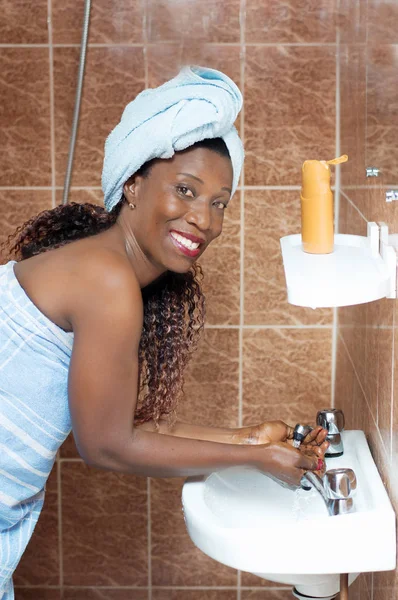 Glückliche junge Frau wäscht sich ihr Gesicht — Stockfoto