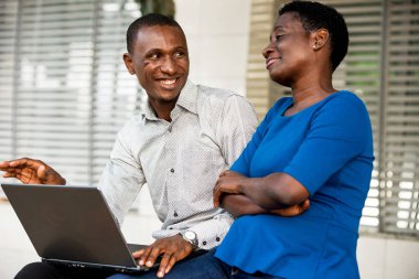 Dizüstü bilgisayarlı gülümseyen gençlerin portresi.