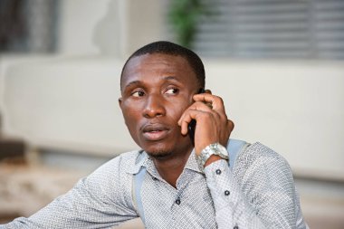 Cep telefonlu genç adama yakın çekim.