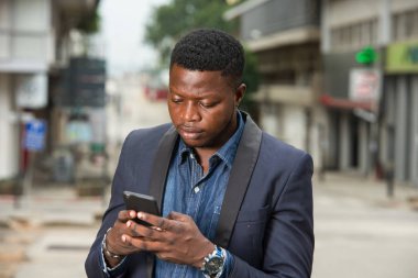 Takım elbiseli adam modern mobil teknolojilerin tadını çıkarıyor..