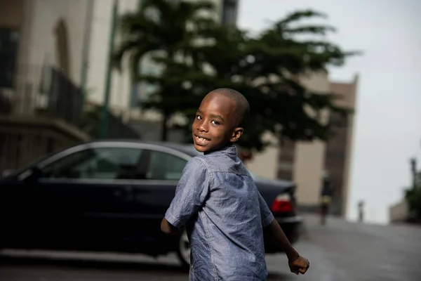 Tişörtlü küçük çocuk koşuyor ve kameraya arkadan bakıyor. — Stok fotoğraf