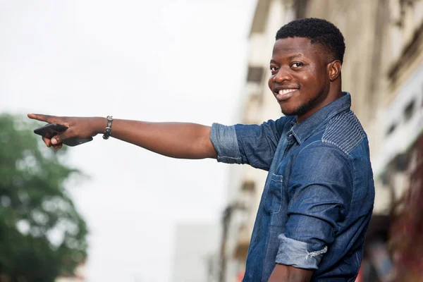 Yol kenarında taksiyi bekleyen genç yakışıklı adam.