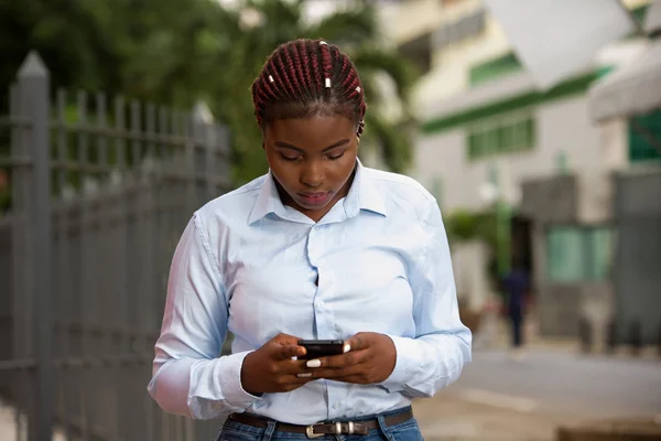 Nachdenkliche Geschäftsfrau hält Smartphone in der Hand und checkt. — Stockfoto