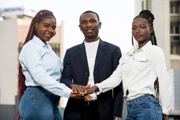 Groep jonge zakenmensen verenigd door handen voor teamwork — Stockfoto