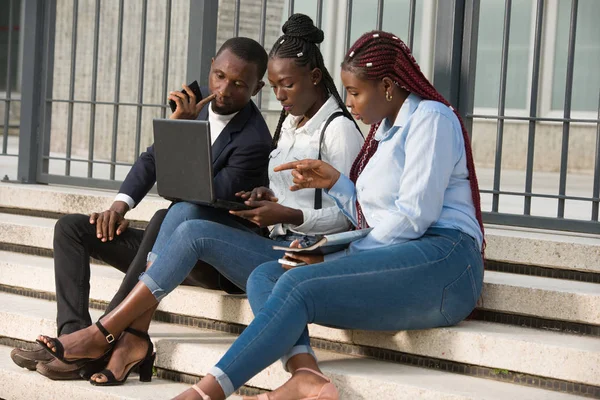 Gruppe junger Menschen mit intelligenten Computern auf Treppen sitzend — Stockfoto