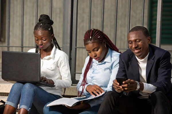 Gruppe junger Menschen mit intelligenten Computern auf Treppen sitzend — Stockfoto