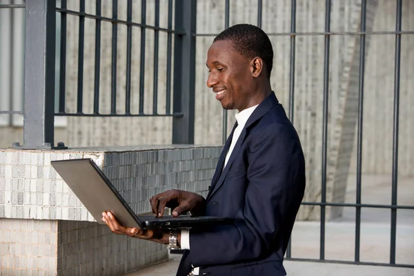 Зображення офісного чоловіка, який працює на ноутбуці перед будівлею — стокове фото