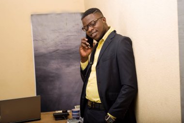 İş adamı ofiste telefonla konuşuyor.