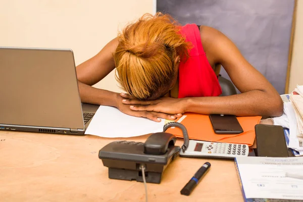 Young exhausted woman asleep on the desk.
