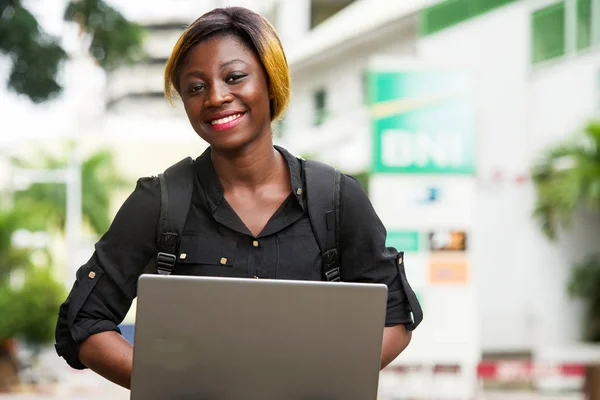 Nahaufnahme einer jungen Studentin mit Laptop, die lächelt. — Stockfoto