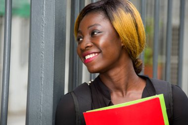 Close-up of young student with documents, happy.