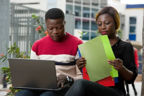 Zwei junge Leute arbeiten draußen am Laptop — Stockfoto