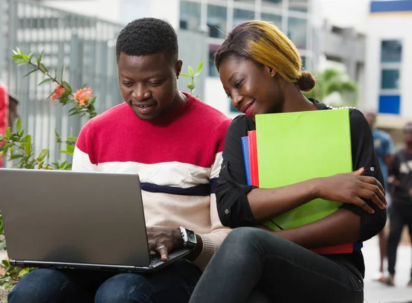 Zwei junge Leute arbeiten draußen am Laptop — Stockfoto