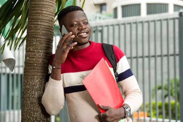 Portrait de jeune étudiant avec téléphone portable, souriant . — Photo