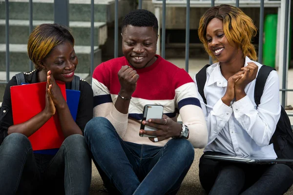 Studenten Die Auf Dem Boden Sitzen Und Ihr Handy Lächelnd — Stockfoto