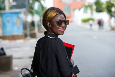 Güneş gözlüğü takan mutlu bir kız öğrencinin portresi.