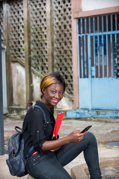 Junge Studentin Sitzt Mit Handy Und Schaut Lächelnd Die Kamera — Stockfoto