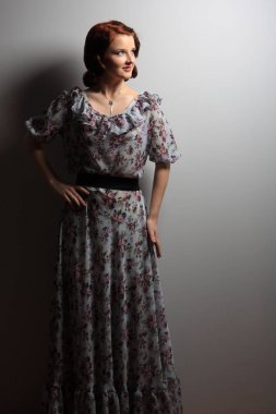 Güzel kız vintage elbise giymiş ve uzak görünüyor.