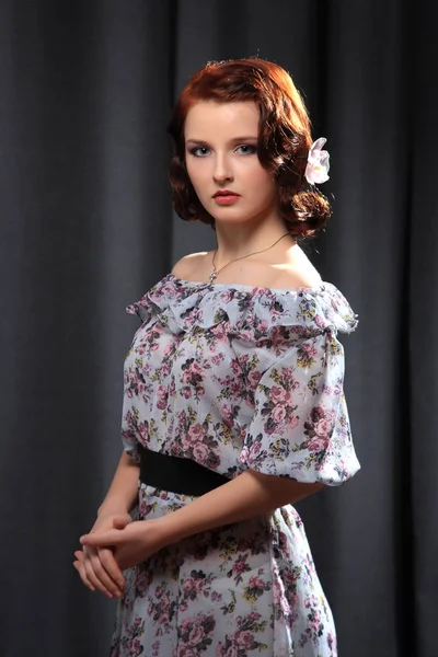 Genç kız mavi çiçek elbise giymiş.