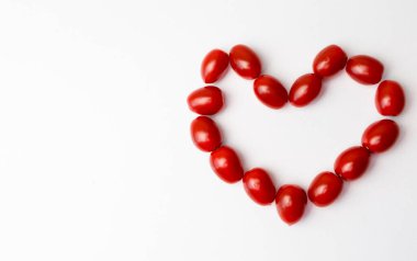 Beyaz arka planda kalp şeklinde domatesler
