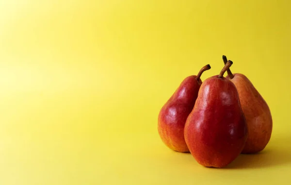 Trois Poires Rouges Sur Fond Jaune — Photo