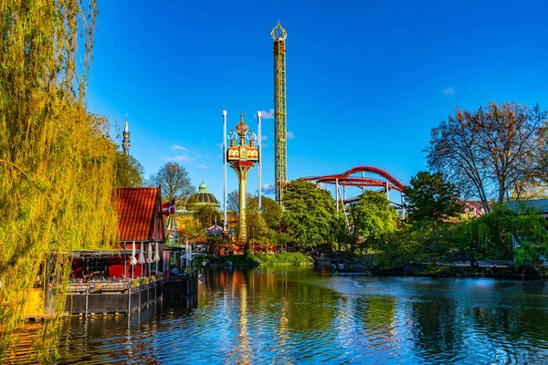 Atrações refletindo sobre uma lagoa no parque de diversões Tivoli em Cop — Fotografia de Stock