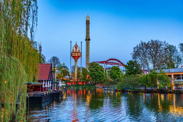 Atracciones que reflexionan sobre un estanque en el parque de atracciones Tivoli en Cop — Foto de Stock