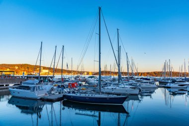 Motorlu tekneler konut binaları arasında bir kanalda demirliyor.