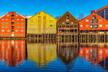 Colorful timber houses surrounding river Nidelva in the Brygge d clipart
