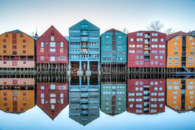 Sunset view of colorful timber houses surrounding river Nidelva  clipart