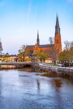 Uppsala katedralinin günbatımı Sw 'daki Fyris nehrine yansıyor.
