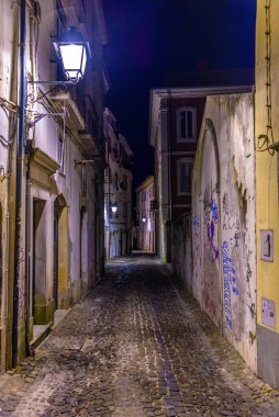 Portekiz 'in eski Coimbra kasabasındaki dar bir caddenin gece görüşü