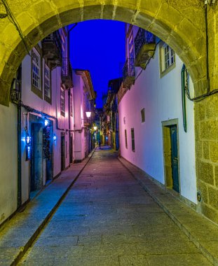 Eski Guimaraes kasabasındaki dar bir caddenin gün batımı manzarası, Por