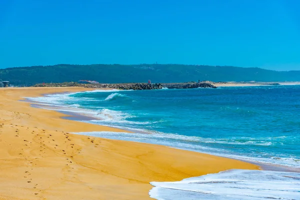 La gente está disfrutando de un día soleado en una playa en Nazare en Portugal — Foto de Stock