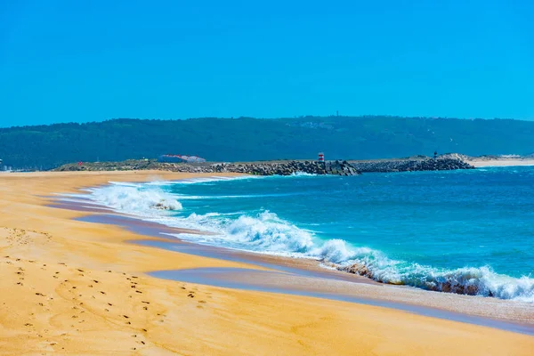 Folk njuter av en solig dag på en strand i Nazare i Portugal — Stockfoto